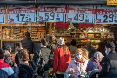 İstanbul, Türkiye. 5 Ocak 2022. Yerliler ve turistler arasında popüler bir gıda pazarı olan Mısır Çarşısı 'nın önünde toplanan turistler, Türk lirası fiyatlarını gösteren tabelalarla karşılaşıyorlar.. 