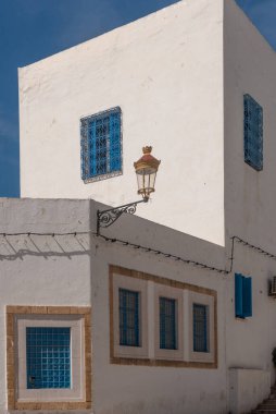 Kuzey Afrika 'nın Akdeniz kıyısındaki Tunus Medine' nin UNESCO dünya mirası sahasında klasik beyaz yıkanmış duvarlar ve Tunus mimarisinin mavi boyalı pencereleri. 