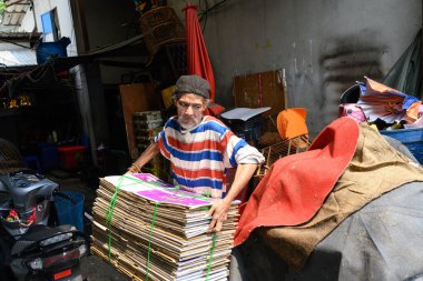 Bangkok, Tayland. 19 Şubat 2025. Khlong Toei Pazarı, Bangkok, Tayland, Asya 'da geri dönüşümlü mukavva toplayan bir adam.