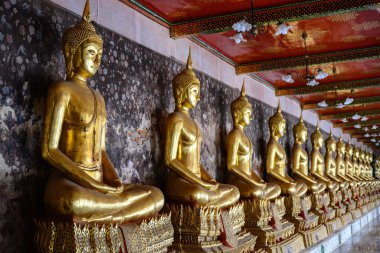 Bangkok, Tayland. 20 Şubat 2025. Thepwararam 'daki Wat Suit' te bir sıra altın Budist heykeli..