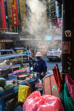 Bangkok, Tayland. 18 Şubat 2025. Yerel bir sokak satıcısı Yaowarat Yolu, Çin Mahallesi, Bangkok, Tayland boyunca içi karpuz dolu bir arabayı itiyor.