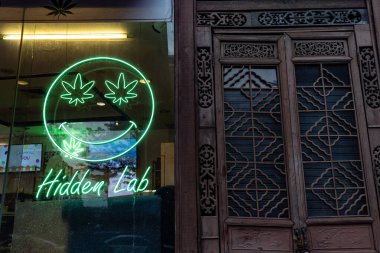 Bangkok, Tayland. 12 Mart 2025. Bangkok, Tayland, Asya 'daki Patpong Gece Pazarı yakınlarındaki ışıklı neon yeşil kenevir yaprağı tabelası..