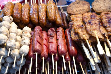 Sai Krok Isan ve Moo Ping 'in de içinde bulunduğu ızgara domuz eti seçimi, çubuğun üzerinde satay tarzı et Tayland' da Bangkok, Tayland 'da tezgahlardan ve marketlerden satılan popüler bir sokak yemeği. 