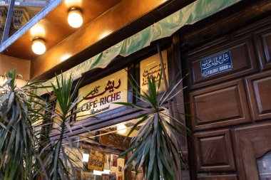Kahire, Mısır. 4 Nisan 2025: Yeşil tente fabrikaları tabelasının yer aldığı Vintage cafe vitrini