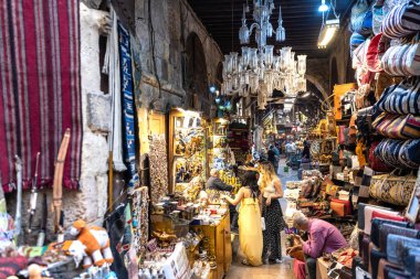 Kahire, Mısır. 21 Nisan 2025: İnsanlar pazarda renkli tekstil ve hediyelik eşya ararken