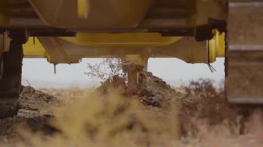 Buldozerin yakın çekimi toprağı gevşetiyor.
