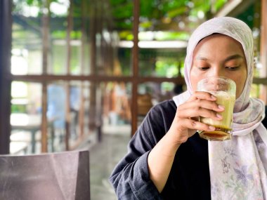 Başörtüsü takan biri kafede içki içer..
