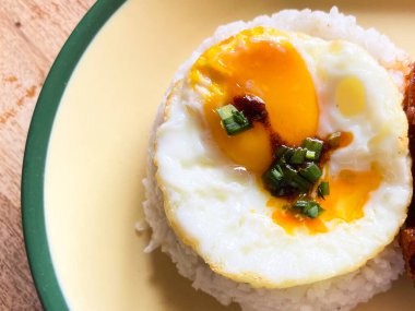 Yumuşak pirinç yatağında servis edilen kızarmış bir yumurta. Basit, ama tatmin edici..