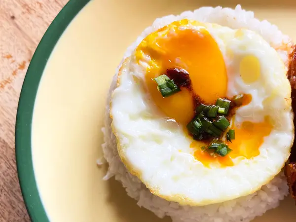 Yumuşak pirinç yatağında servis edilen kızarmış bir yumurta. Basit, ama tatmin edici..