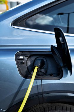 Modern elektrikli arabayı şarj etmek için bir elektrik şarj istasyonu kullanın. Ekonomik yükleme ve modern teknolojiler kavramı. 