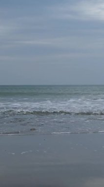 Deniz kıyısı, sahil. Sahildeki dalga köpüğü. bulutlu hava