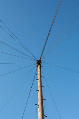 Etrafında bir sürü kablo olan tek bir direk gökyüzüne karşı tek düğüm şeklinde bağlanmış. - Evet. Yüksek kalite fotoğraf