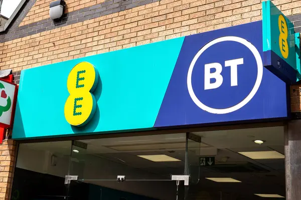Corby, Willow Place 'in dışındaki EE ve BT mağazalarının birleşimi. İşarette belirgin renkler ve logolar yer alıyor..