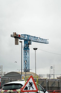 İnşaat alanı vinçleri bulutlu gökyüzüne karşı. Yol çalışıyor. Yüksek kalite fotoğraf