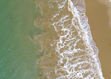 Sahildeki kumlara karşı dalgaların havadan görünüşü