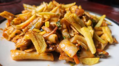 Lezzetli bir tabak makarna, çıtır patates kızartması, taze sebze ve makarna, hepsi lezzetli bir sos ile karıştırılmış..