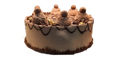 Çikolata soslu, üzerinde çikolata topları ve girdaplar olan ve altın yapraklı aksanla süslenmiş güzel dekore edilmiş bir çikolatalı pasta. Pastada karışık çikolata çiselemesi ve kırıntılarla kaplı bir taban var..