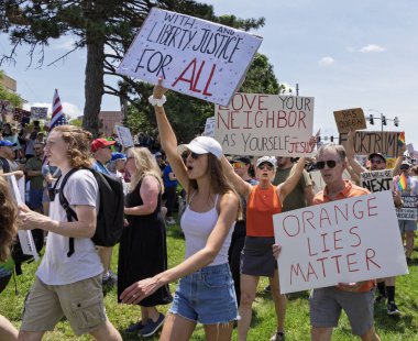 Bir grup protestocu ellerinde adalet ve eşitliği savunan işaretler tutuyorlar..