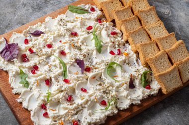 Yağlı tahtayı beyaz kaplamalı ve gri arkaplanlı mini tostlu. Üst görünüm