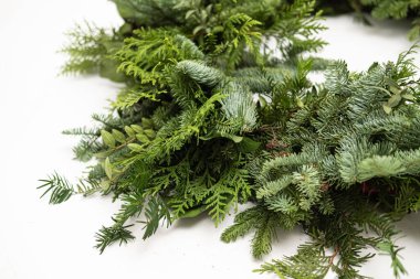 Kozalaklı ağaçların yaşayan dallarından oluşan Noel çelenklerini kapatın. Yeni yıl dekorasyonu. Sıfır atık. Bulanık ve seçici odaklanma