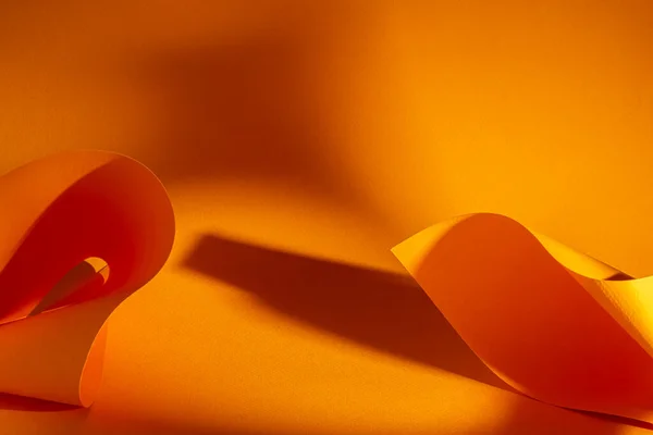 Abstract orange background with shadows and paper installations. Shadow and beams of natural light effects. Copy space