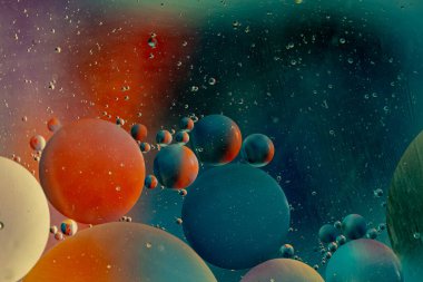 Su emülsiyonundaki yağ, mavi arka plandaki yüzey geriliminden dolayı yağ damlalarının kabarcıklar oluşturduğu soyut arka plan kavramı. Uzayın muhteşem bir resmi. Dikey makro fotoğraf, seçici odak 