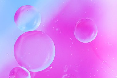 Pembe yumuşak tonlarda soyut bir arkaplan. Su yüzeyine makro yağ damlaları. Reklam ürünleri için hassas kozmetik arka plan. Boşluğu kopyala