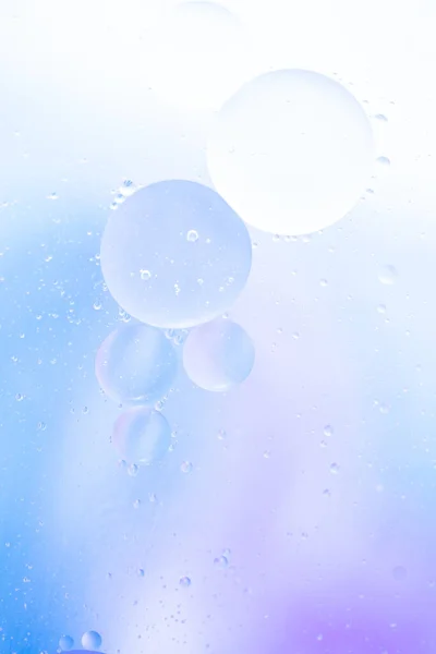 Delicate cosmetic background for promotional products in pale blue-violet colors. copy space and gradient. lilac-blue tones. Beautiful bubbles, vertical photo.