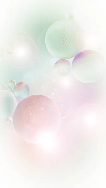 Abstract backdrop bubbles in pale pink green tones. Distortion in water with oil drops with len flare effect. gradient, flashing lights. Unusual background for stories