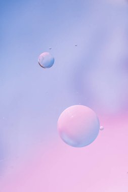 Leylak yumuşak tonlarında soyut bir arkaplan. Su yüzeyine makro yağ damlaları. Reklam ürünleri için hassas kozmetik arka plan. Boşluk ve gradyanı kopyala