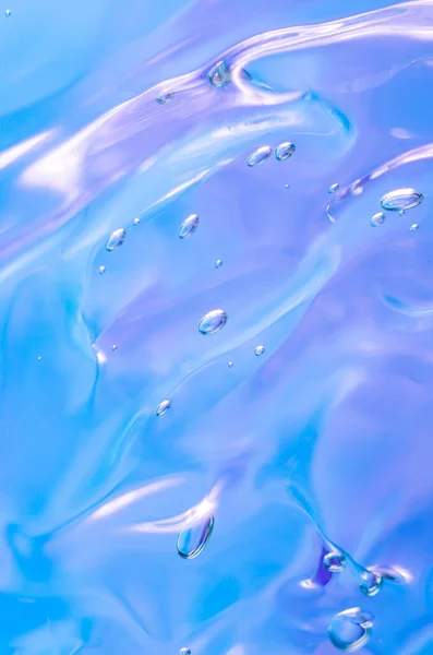 化粧品のゲルの質感 泡のある青い背景の透明なクリーム マクロ写真 ぼかしと選択的フォーカス 垂直写真 — ストック写真