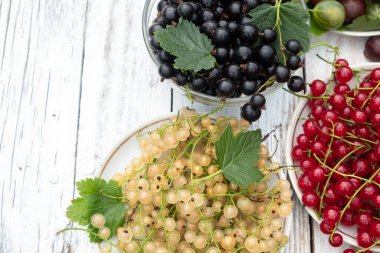 Ahşap bir masada kırmızı, siyah ve beyaz üzümler. Bulanık ve seçici odaklanma. Üst görünüm 
