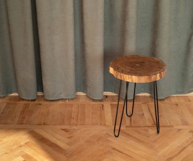 Masa, koyu yeşil perdelerden oluşan arka planda kesilmiş ahşaptan yapılma. Doğal ürünlerin sunumu ve satışı için podyum. Minimalizm, doğal stil.