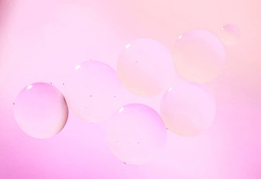 Su yüzeyine makro yağ damlaları. Yumuşak mavi bej tonlarda kozmetik ürünlerin reklamları için hassas kozmetik kabarcıklar arka planı, gradyan. 