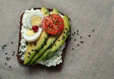 Süzme peynir, avokado, yumurta ve domatesli sağlıklı tost. Sağlıklı bir atıştırma.