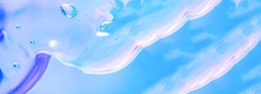 Kozmetik ürünlerin jel dokusu. Mavi arka planda köpüklü şeffaf krem. makro fotoğraf. bulanık ve seçici odak