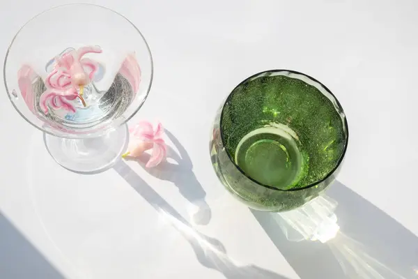 stock image Green glass goblet with water. Abstract shadow pattern on white background. Texture for the background