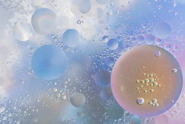 Su yüzeyine makro yağ damlaları. Reklam ürünleri için soluk mavi renklerde narin bir kozmetik arka plan. Boşluk ve gradyanı kopyala. 