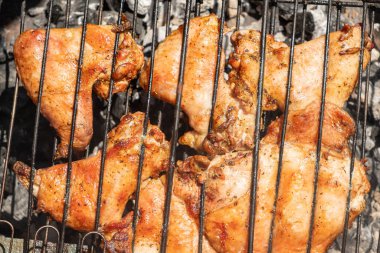 Izgarada ızgara yapılmış leziz, baharatlı tavuk parçaları yakın plan, açık hava yemeklerinin lezzetli, dumanlı tadını yakalıyor. Üst görünüm.