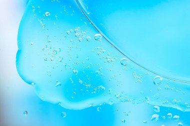 Baloncuklu ve damlacıklı mavi sıvının yakın çekimi soyut, ferahlatıcı ve temiz bir görünüm yaratıyor. Geçmişler, su temaları ve taze kavramlar için ideal.