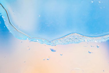 Baloncuklu ve damlacıklı mavi sıvının yakın çekimi soyut, ferahlatıcı ve temiz bir görünüm yaratıyor. Geçmişler, su temaları ve taze kavramlar için ideal.