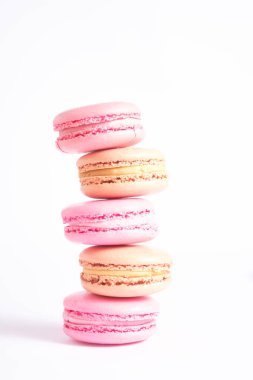 Temiz beyaz arka planda minimalist dikey pembe ve bej makaronlar. Mutfak teması, tatlı fotoğrafçılığı ve reklamcılık için mükemmel. Fotoğraf estetiği. 