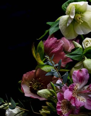 Çiçek arkaplanı. Siyah arka planda Hellebores ve Alstromeria çiçeklerinden bir buket. Uzayı kopyala Bulanık arkaplan