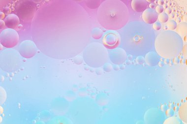 Su makro dokusunda yumuşak pembe, mavi ve leylak yağı damlaları. Yaratıcı arka planlar ve zarif tasarımlar için yuvarlak şekilli yumuşak pastel gradyan