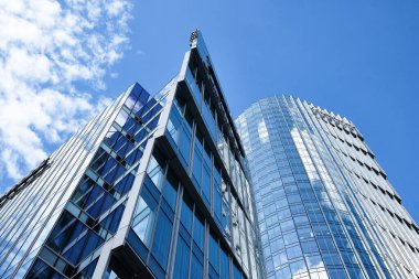 Varşova, Polonya, Ağustos 2025. Modern cam gökdelenler. Açık gökyüzünün altındaki mavi camlara yansıyan çağdaş kentsel mimari. Aşağıdan görüntüle