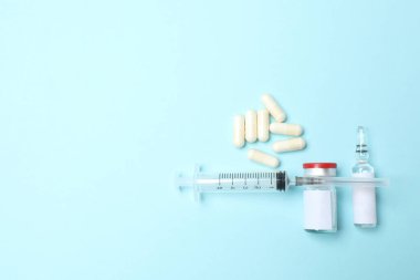 Renkli arka planda haplar, şırınga ve su şişesi bileşimi