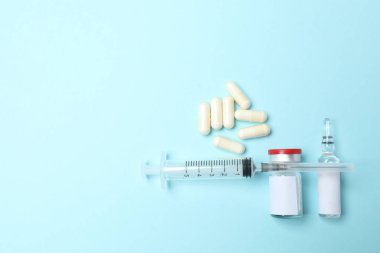 mavi arka planda farklı haplar ve şırıngalar. Düz yat. en üstteki görünüm.