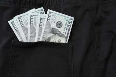 Cebinde siyah pantolonla bir dolar..