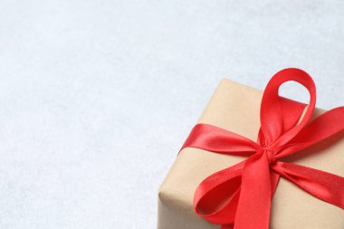 Kırmızı kurdeleli kırmızı hediye kutusu ve beyaz arka planda yay