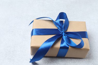 Gri arkaplanlı mavi kurdeleli Noel hediyesi kutusu